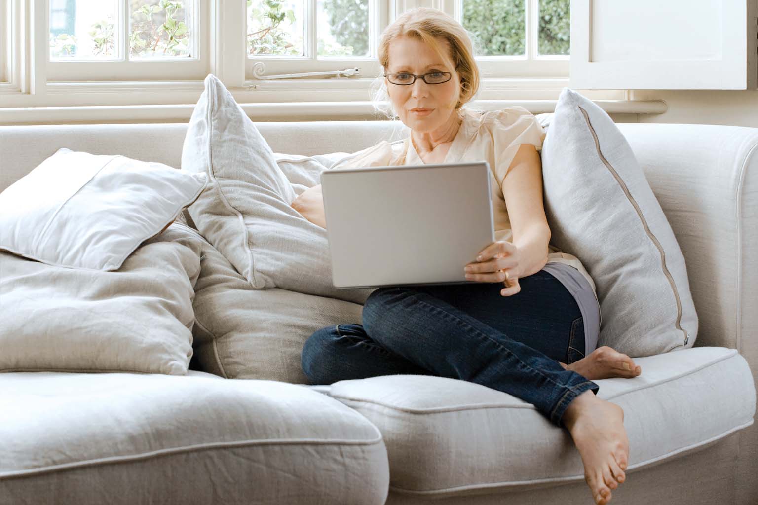 woman on couch using laptop