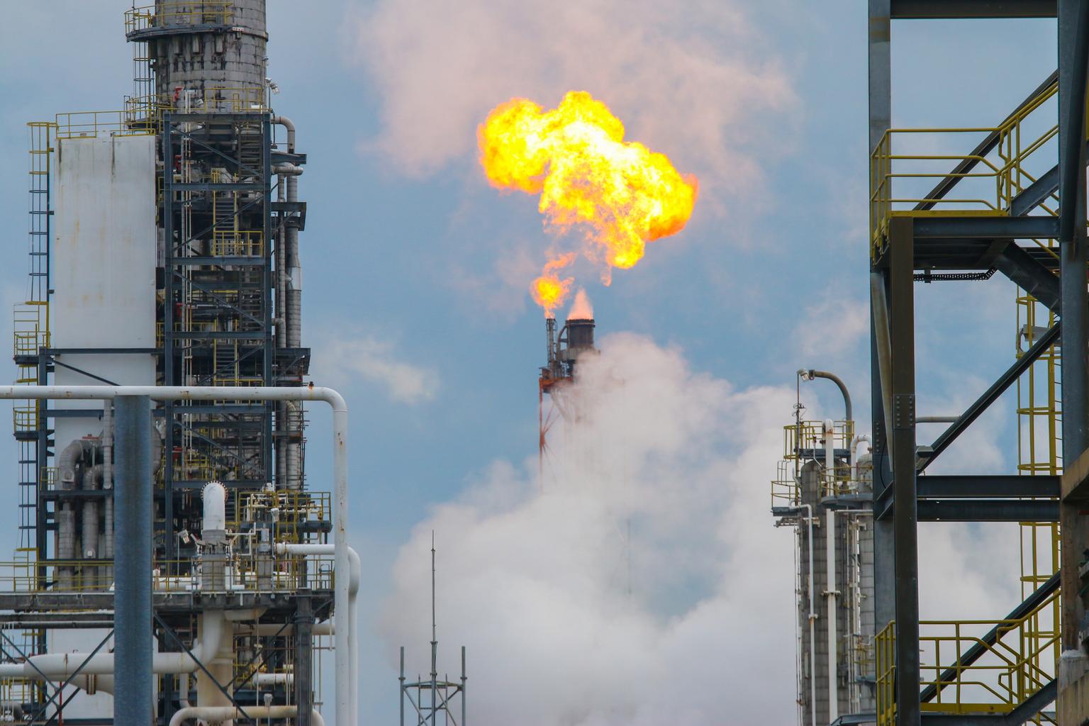 Flare Stack at Oil and Gas Refinery and Petrochemical Plant. It is covered by thick white smoke.