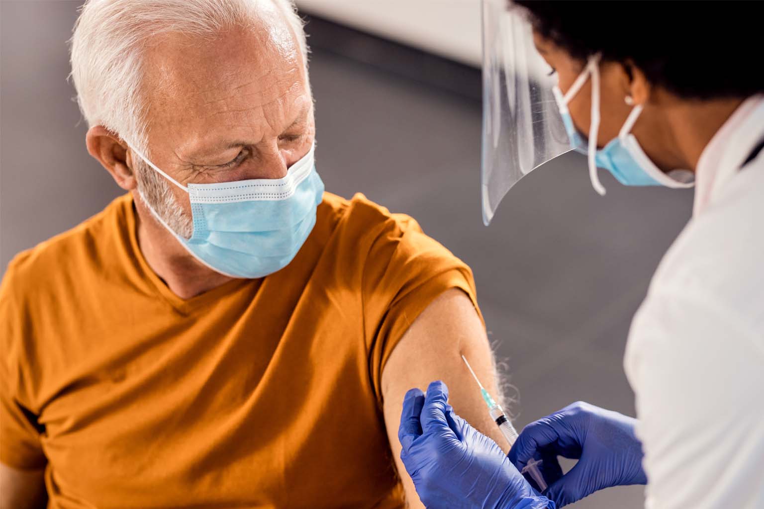 mature male receiving Covid vaccine