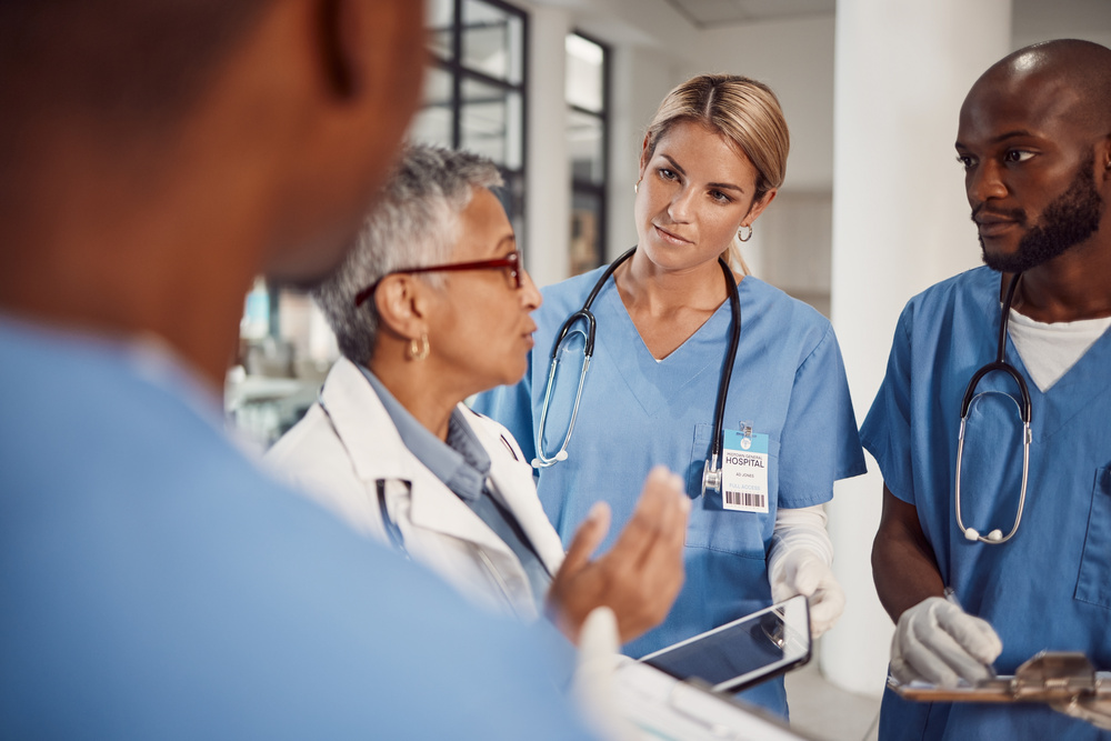 Experienced medical professional in the center of a group of PA residents, giving educational lecture