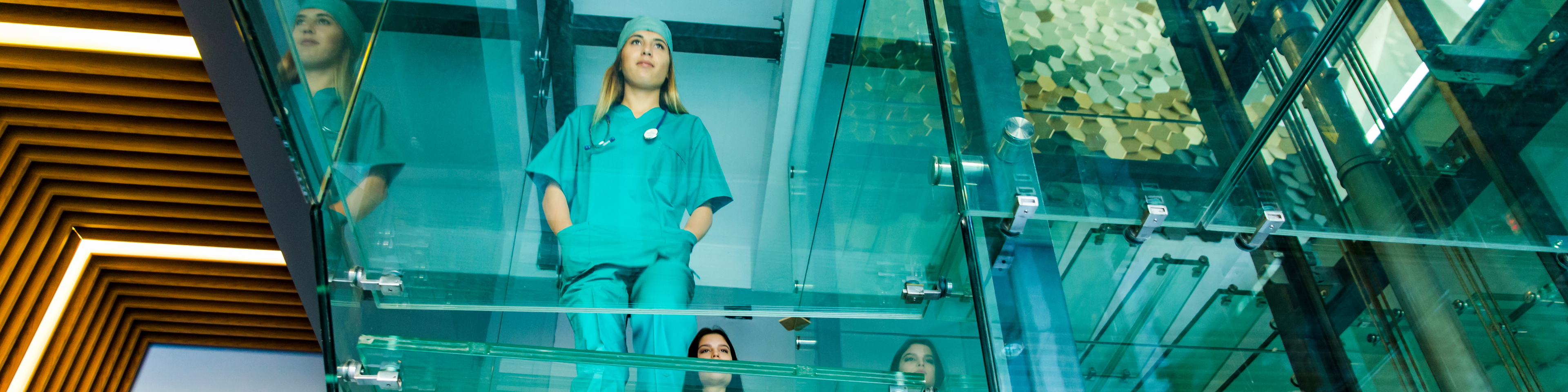 Group of nurses walking up glass stairs in hospital