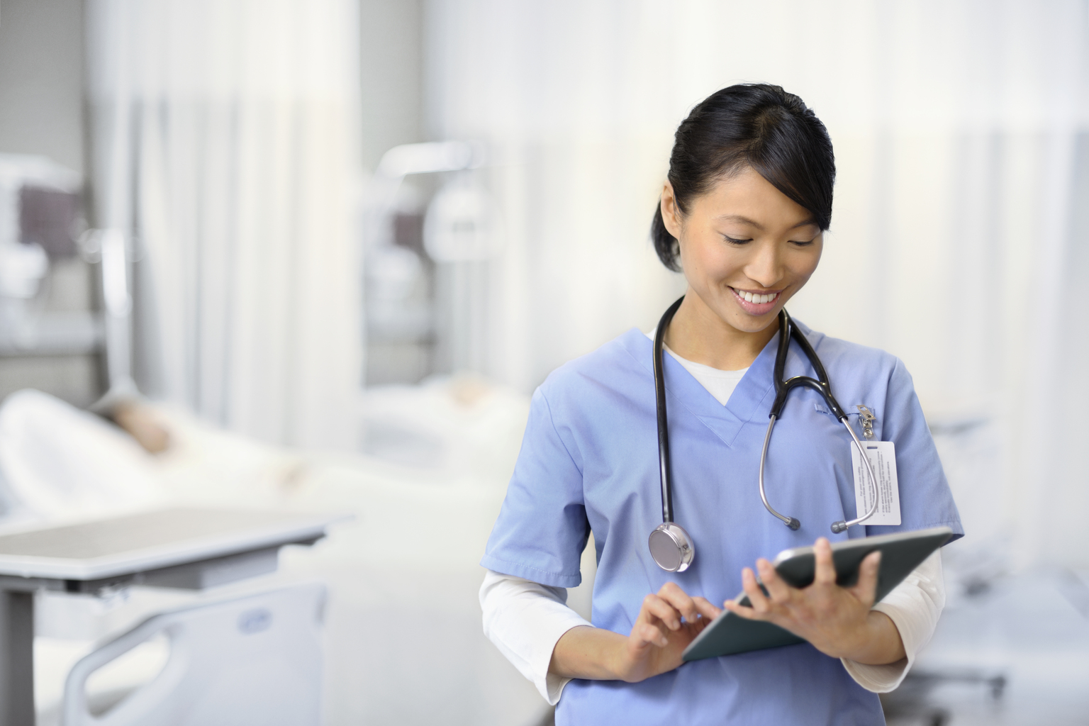 Young Asian female nurse working on a tablet computer.