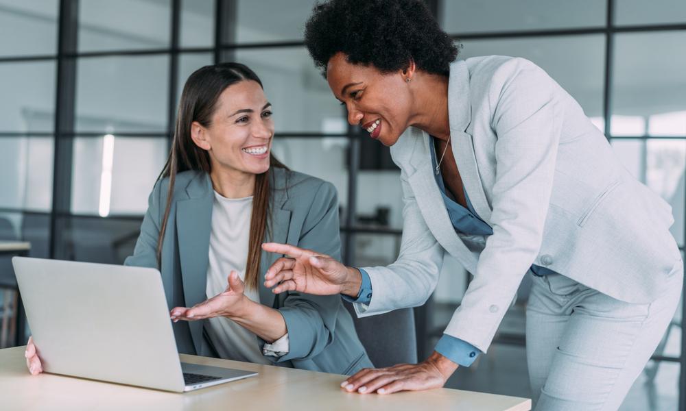 Zwei Frauen diskutieren an einem Arbeitsplatz über den Nutzen von Archivierungssystemen