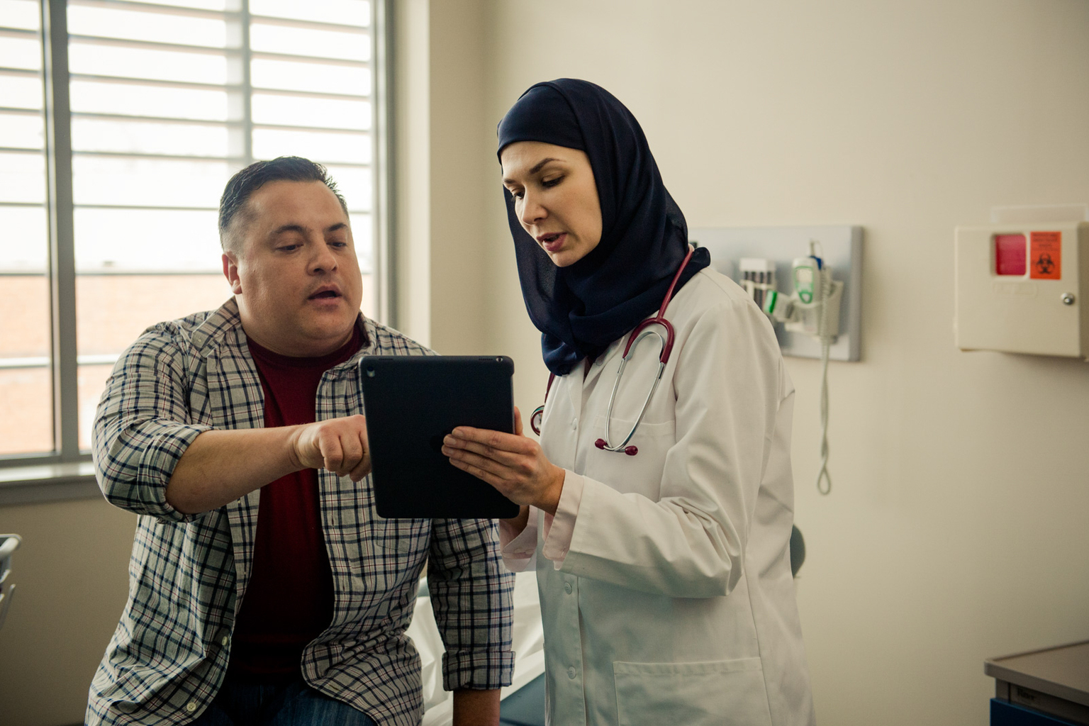 Patient instructing a doctor off a tablet