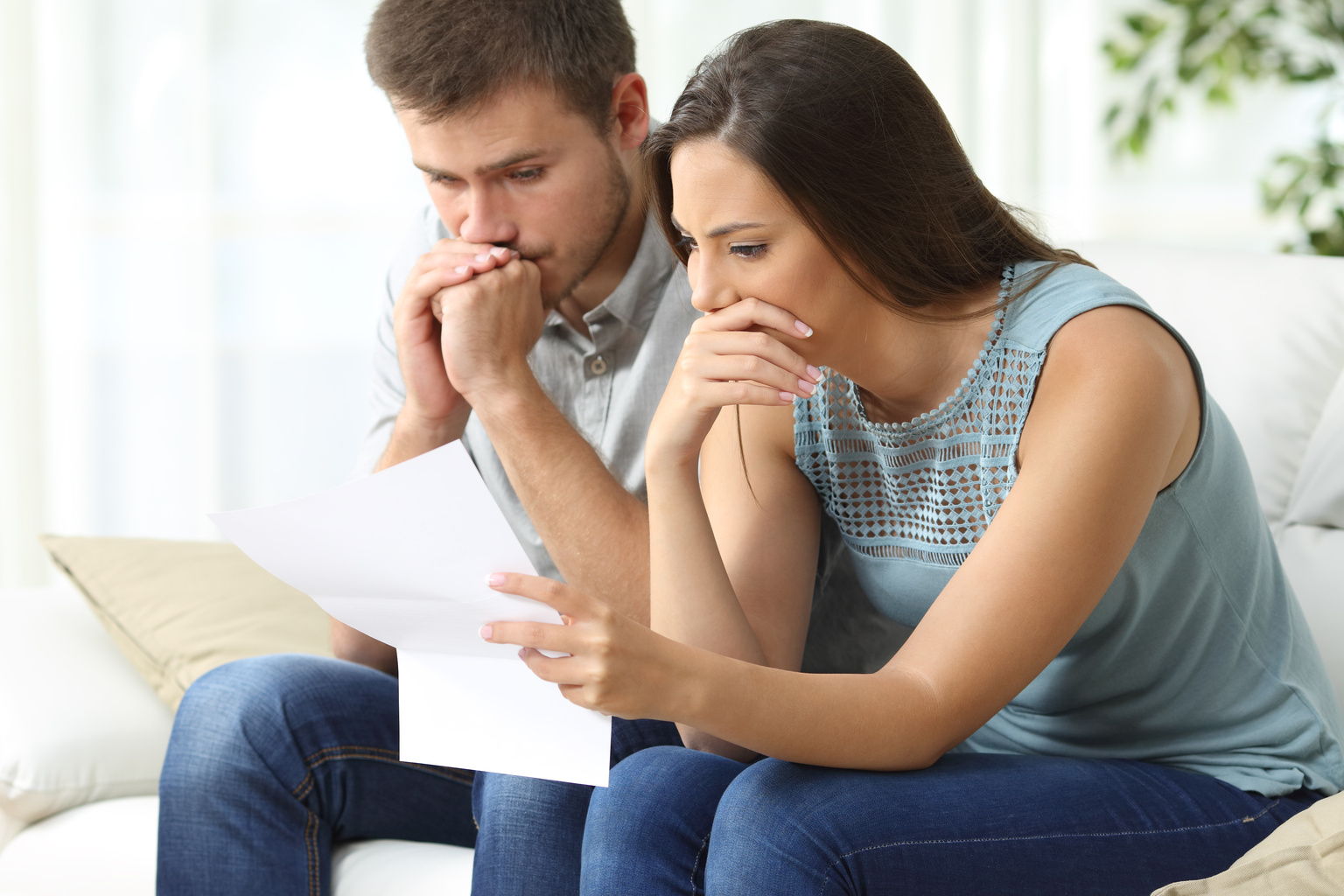 Worried couple reading a letter