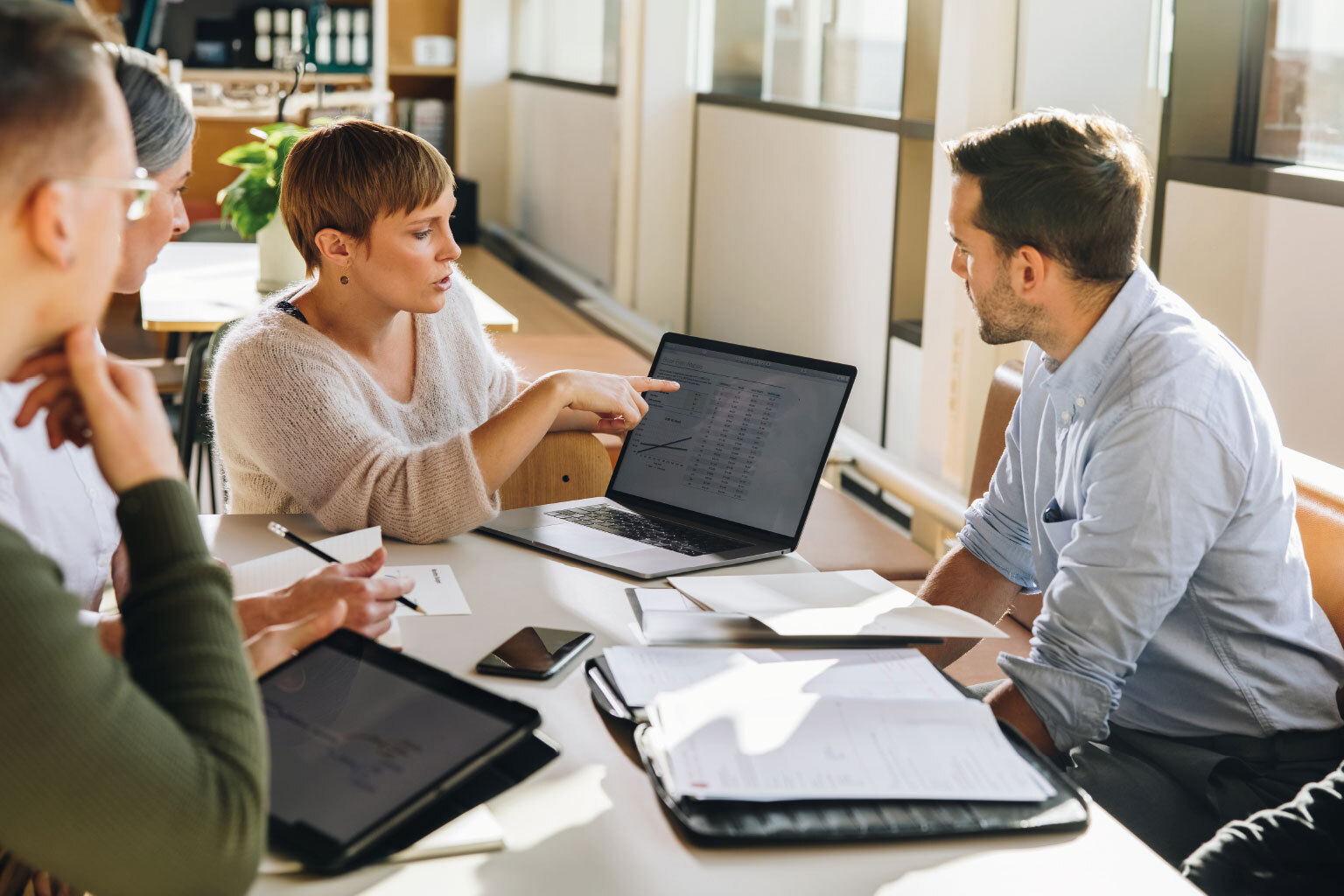 Female executive showing data to team in meeting