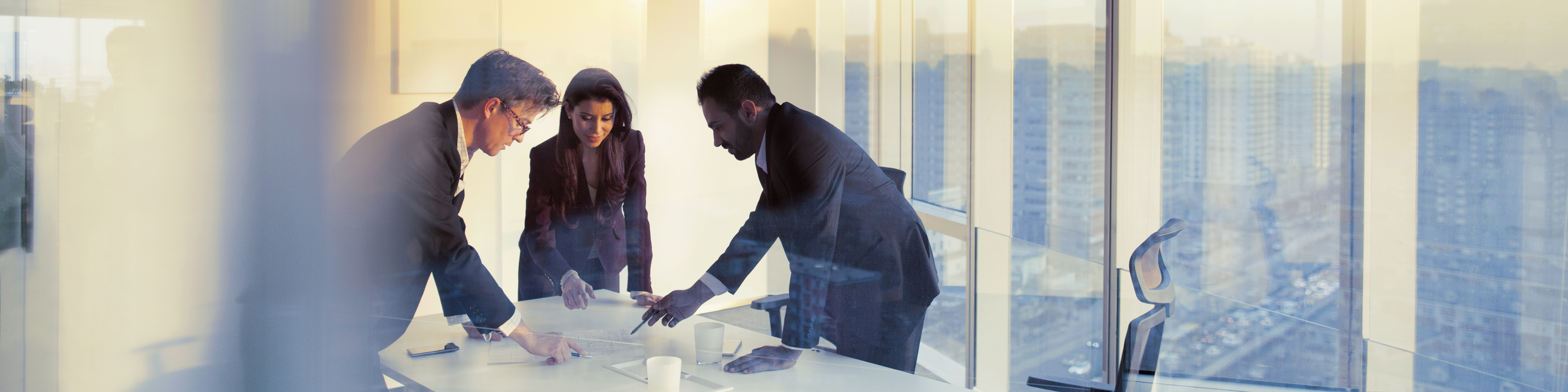 Employees Standing and Discussing on Paper