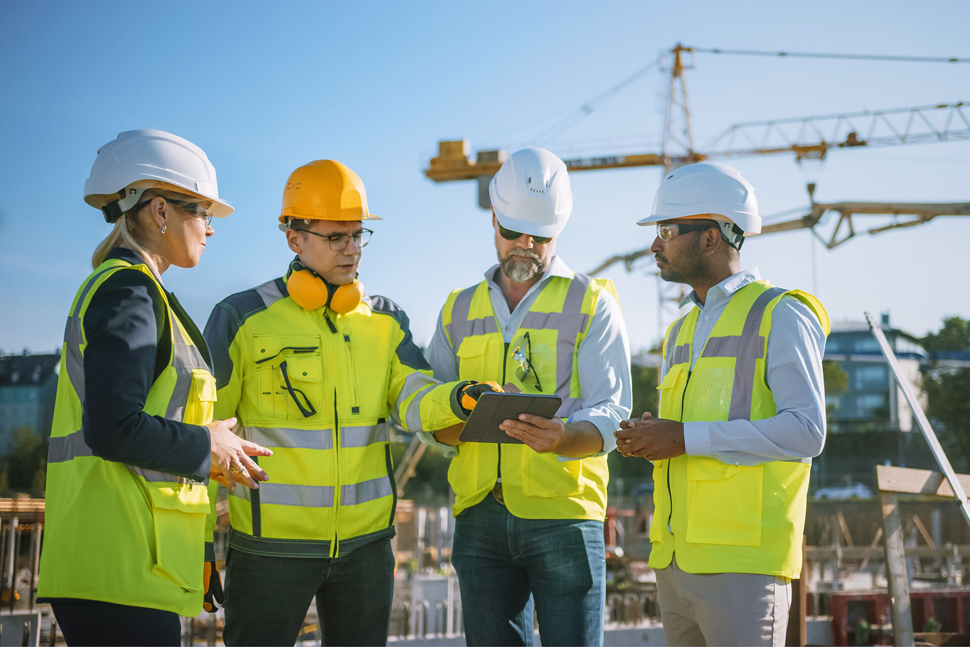 5 construction workers wearing hard hats discussing license requirements